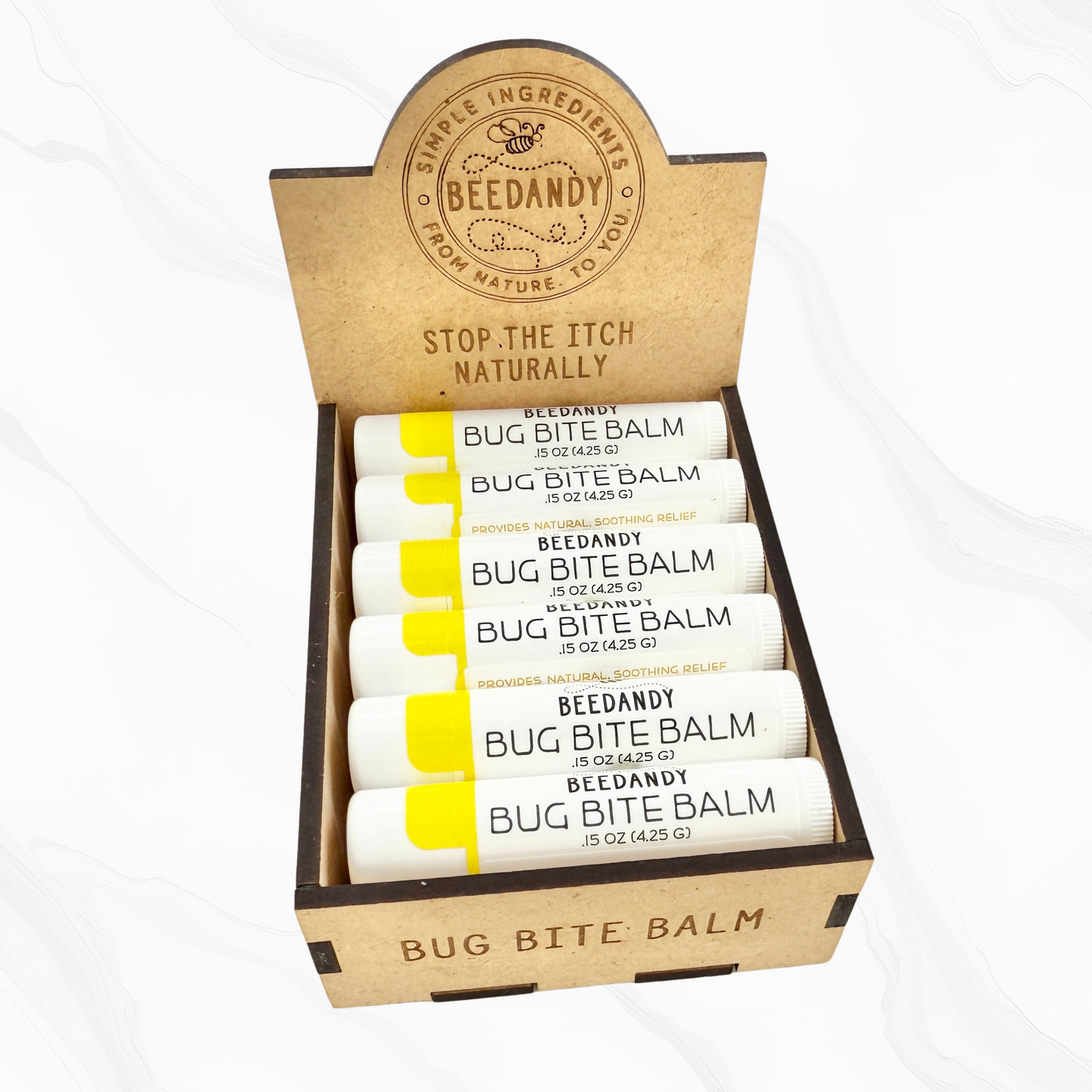 A wooden retail display box for bug bite balms, holding 12 stick-shaped balms, with a sign above that reads 'Bug Bite Balm' and has the brand name 'Beedandy' on it.