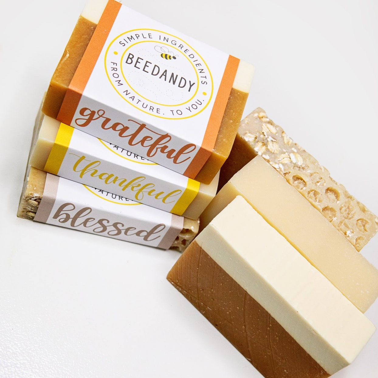 Three unlabeled soaps and three bar soaps labeled 'grateful', 'thankful', and 'blessed'. All against a white background.