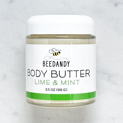 Beedandy Lime Mint Body Butter in a small clear glass jar with a white lid, shown on a light gray background. The label features a bee logo and reads “Body Butter, Lime Mint, 3.5 oz (99 g),” with a green accent band at the bottom.