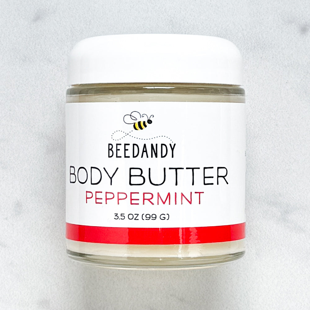 Beedandy Peppermint Body Butter in a small clear glass jar with a white lid, shown on a light gray background. The label features a bee logo and reads “Body Butter, Peppermint, 3.5 oz (99 g),” with a red accent band at the bottom.