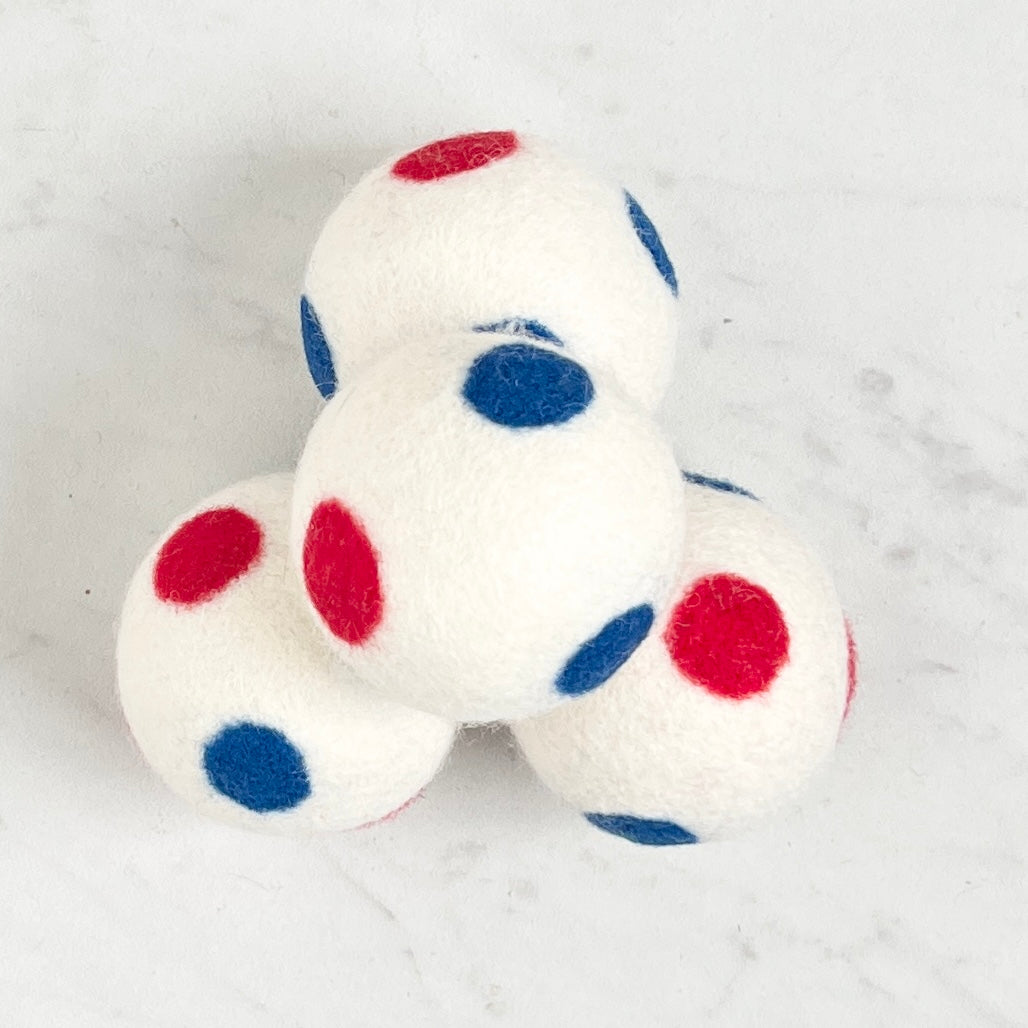 set of 4 white dryer balls with red and blue  dots, on white background