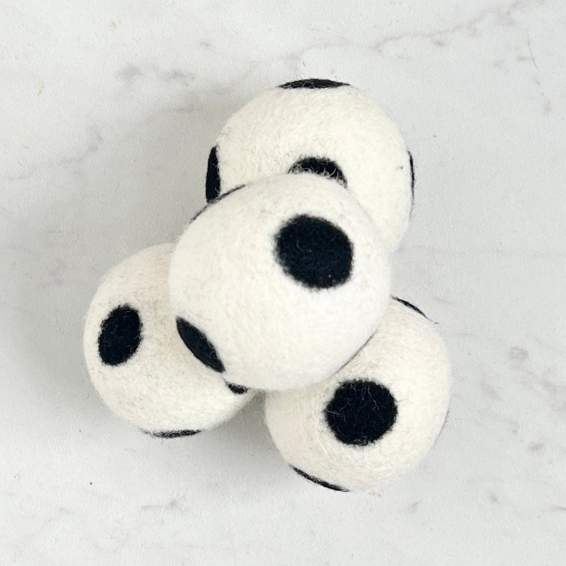 set of 4 white dryer balls with black dots, on white background