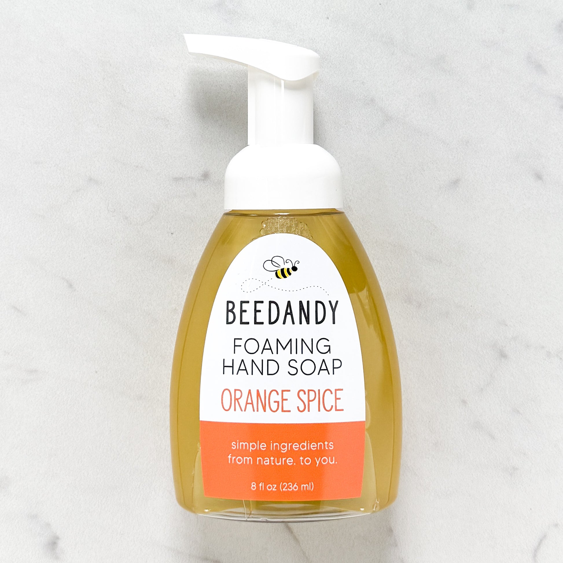 Beedandy orange spice foaming hand soap in a clear pump bottle with white dispenser on a light background.