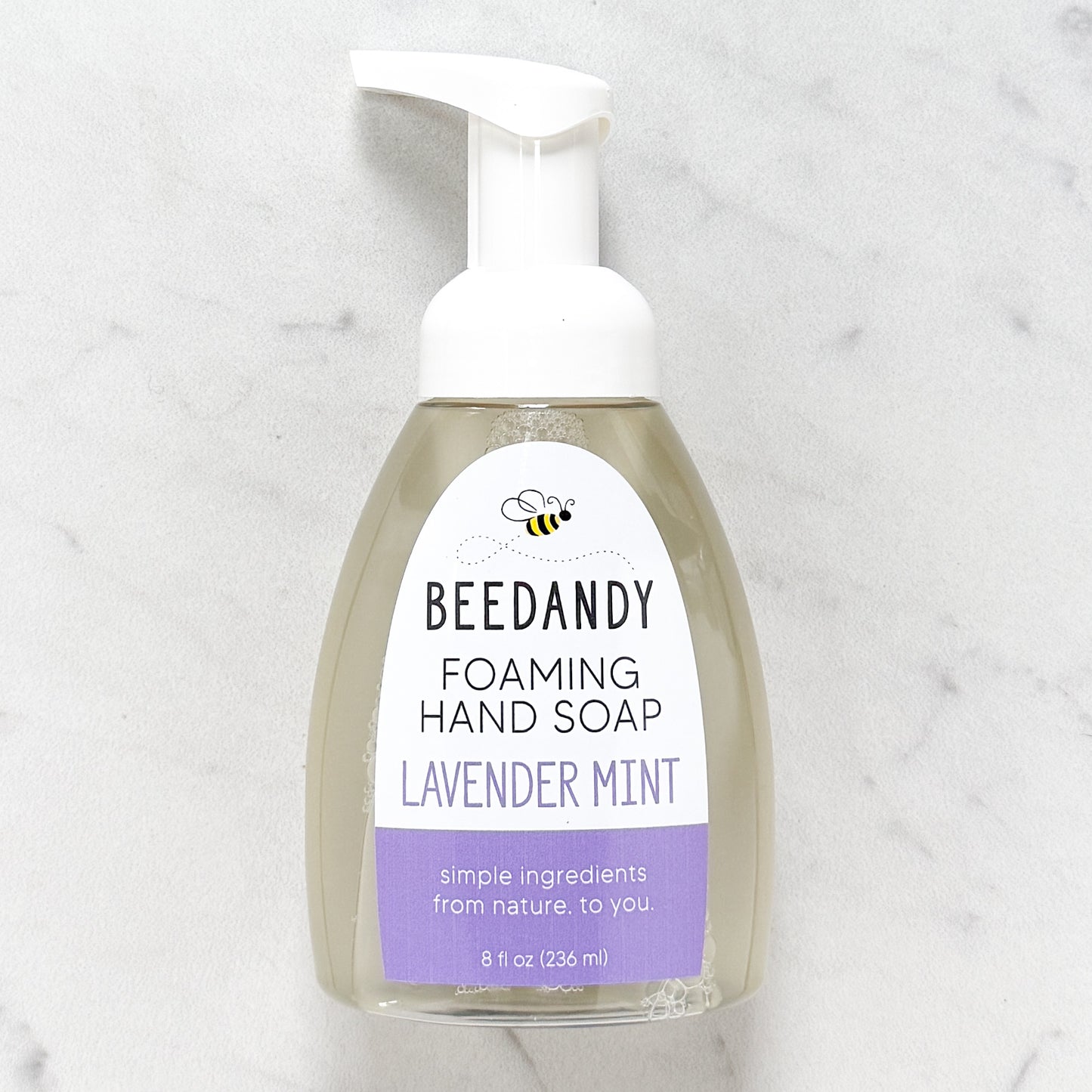 Beedandy lavender mint foaming hand soap in a clear pump bottle with white dispenser on a light background.