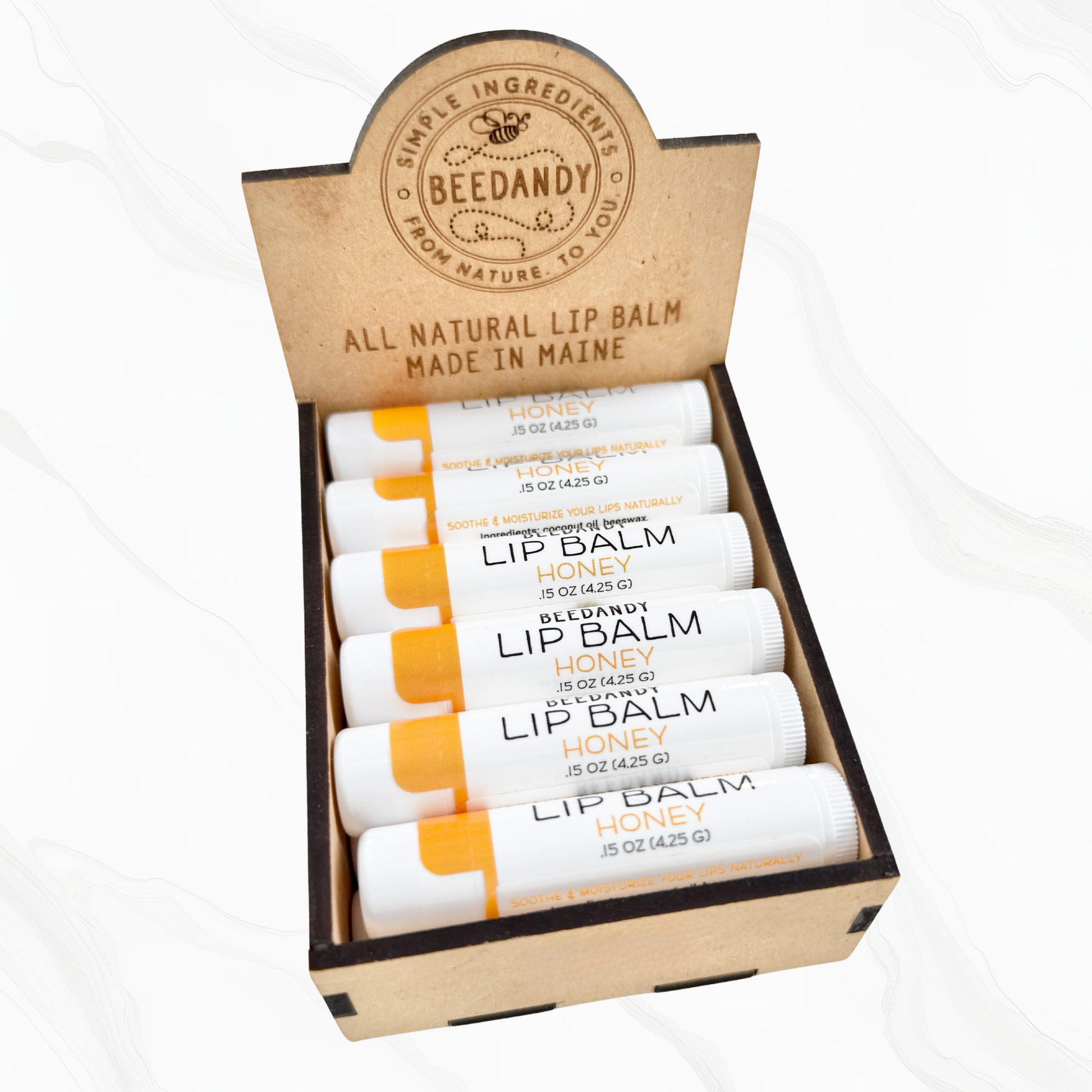 A wooden retail display box for lip balms, holding 12 stick-shaped balms, and has the brand name 'Beedandy' on it.
