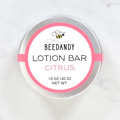 A metal tin of BEEDANDY citrus lotion bar on a white background.
