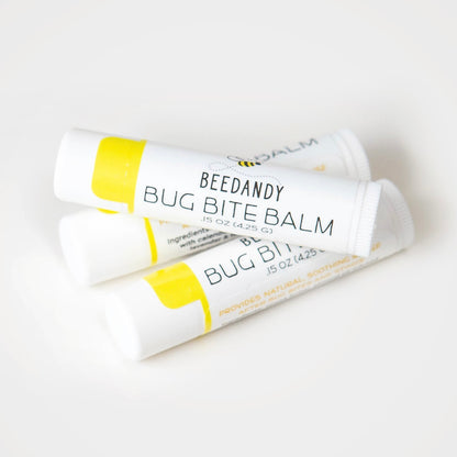 Three small white tubes with yellow labeling labeled Bug Bite Balm. All on a white background. One tube stacked on top of bottom two tubes. 