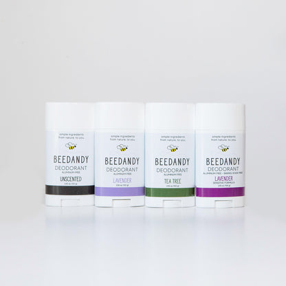 4 Beedandy natural deodorant sticks in lavender, tea tree, and unscented varieties standing up on a white background.